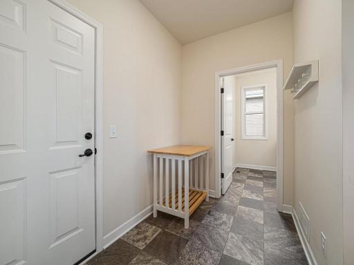 Mudroom entrance to the main floor laundry room. The door to the left goes into attached garage. Makes it easy getting groceries into your kitchen. It has a screen door so you can open the garage door to move cooler air thru the home.