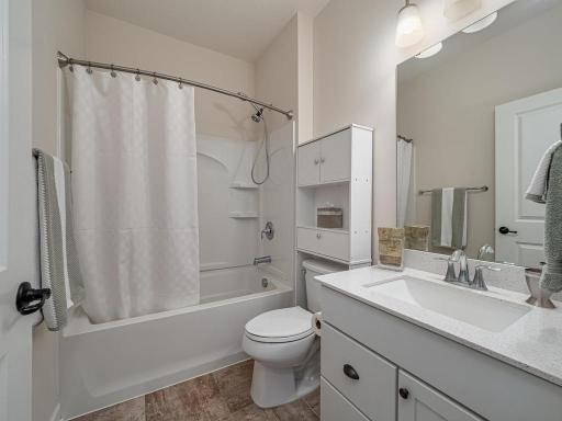 Main level full bath . Quartz countertop and oversized rectangular sink.