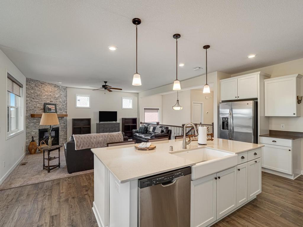 Farmhouse sink featured in the center island makes it easy to load the dishwasher. Quartz countertop .
