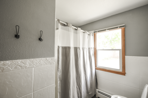 Updated bathroom with vinyl replacement window, updated tile, paint and lighting.