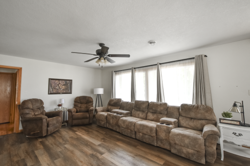 Spacious living room with updated ceiling fan, paint, and flooring. Lots of different ways to rearrange furniture with all this room!