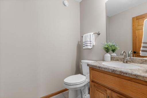 Updated main floor guest bath features a new countertop, faucet, lighting and toilet.