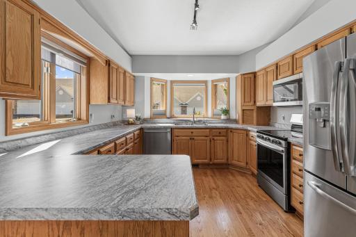 Updated kitchen features new countertops, convenient pull-out cabinet drawers and newer appliances. Walls of windows bring in the sun- making it light and bright.