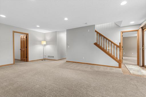 In-floor heat keeps the lower level warm and cozy throughout the Minnesota winter. The den/office is located on the left side of the photo, and the third bedroom is located near the landing.