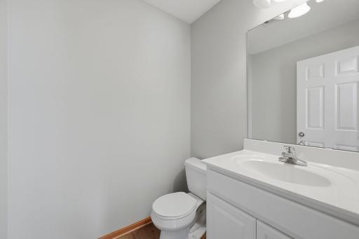 Conveniently located on the main level, the powder room provides easy access for guests and features a bright vanity with generous counter space and a large wall mirror.