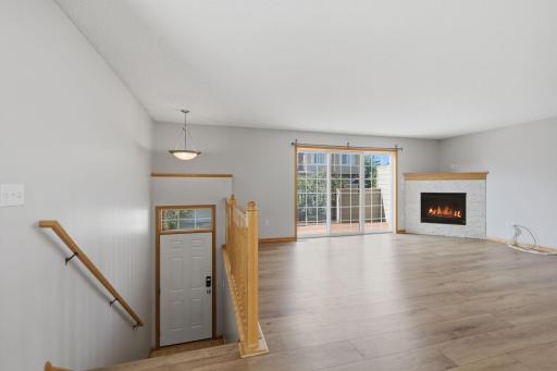 The spacious living room features LVP flooring and a gas fireplace, creating a warm and inviting focal point while leaving plenty of room for multiple furniture arrangements.