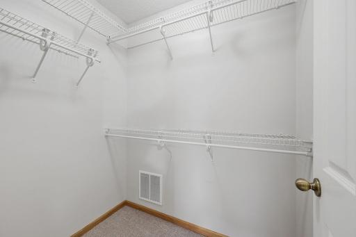 Located through the ensuite bathroom, the spacious walk-in closet features wraparound shelving and hanging space to provide plenty of room for organized wardrobe storage.