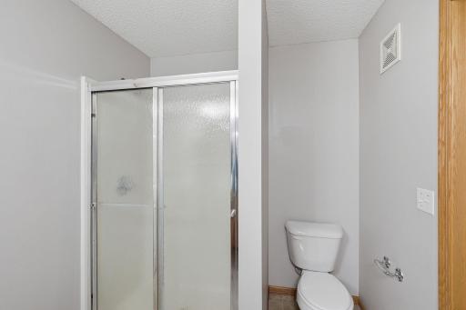 A step-in shower completes the primary ensuite, offering a convenient separate shower area and rounding out this functional private bath.