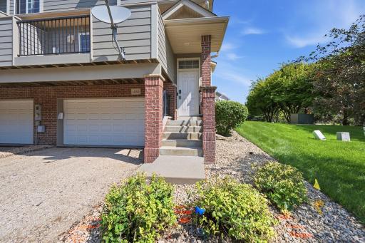 A private front entrance welcomes you home, framed by attractive brick accents and low-maintenance landscaping. The attached garage provides convenient everyday access, while the elevated entry adds definition and character to the exterior.
