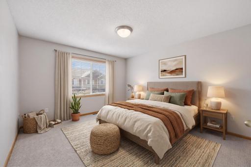 The spacious primary bedroom offers plenty of room for a full bedroom suite, with a large window bringing in natural light and creating a bright, comfortable retreat. -Virtually Staged