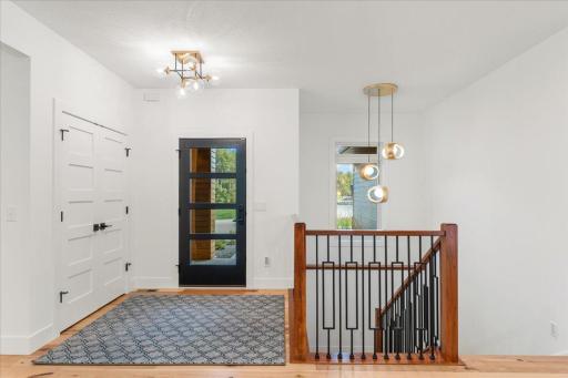 A beautiful foyer with custom lighting, custom window-film for privacy, large foyer closet and much more