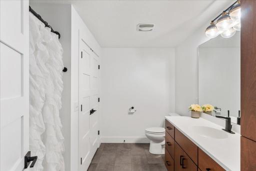 The full bathroom located in the lower level has storage galore, a tub and all the storage you could desire