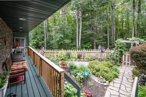 The covered front deck is the perfect place to enjoy the courtyard woods beyond.