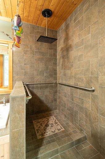 Convenient walk-in shower features tiled floors/walls and "rain shower" head!