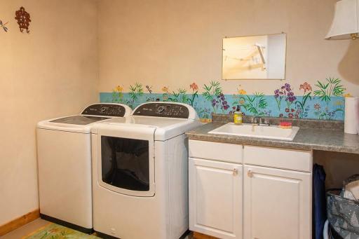 Laundry area features tub & cabinet space. Gas dryer hookup. Clothes line drying area. Also storage closet to right side.