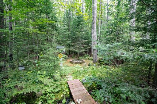 Step across the "bridge" to the dining/kitchen side to the firepit and water feature!