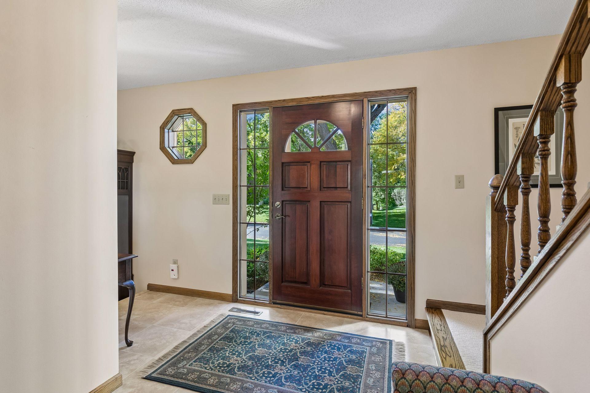Functional & spacious front entry w/ neutral laminate tile flooring.
