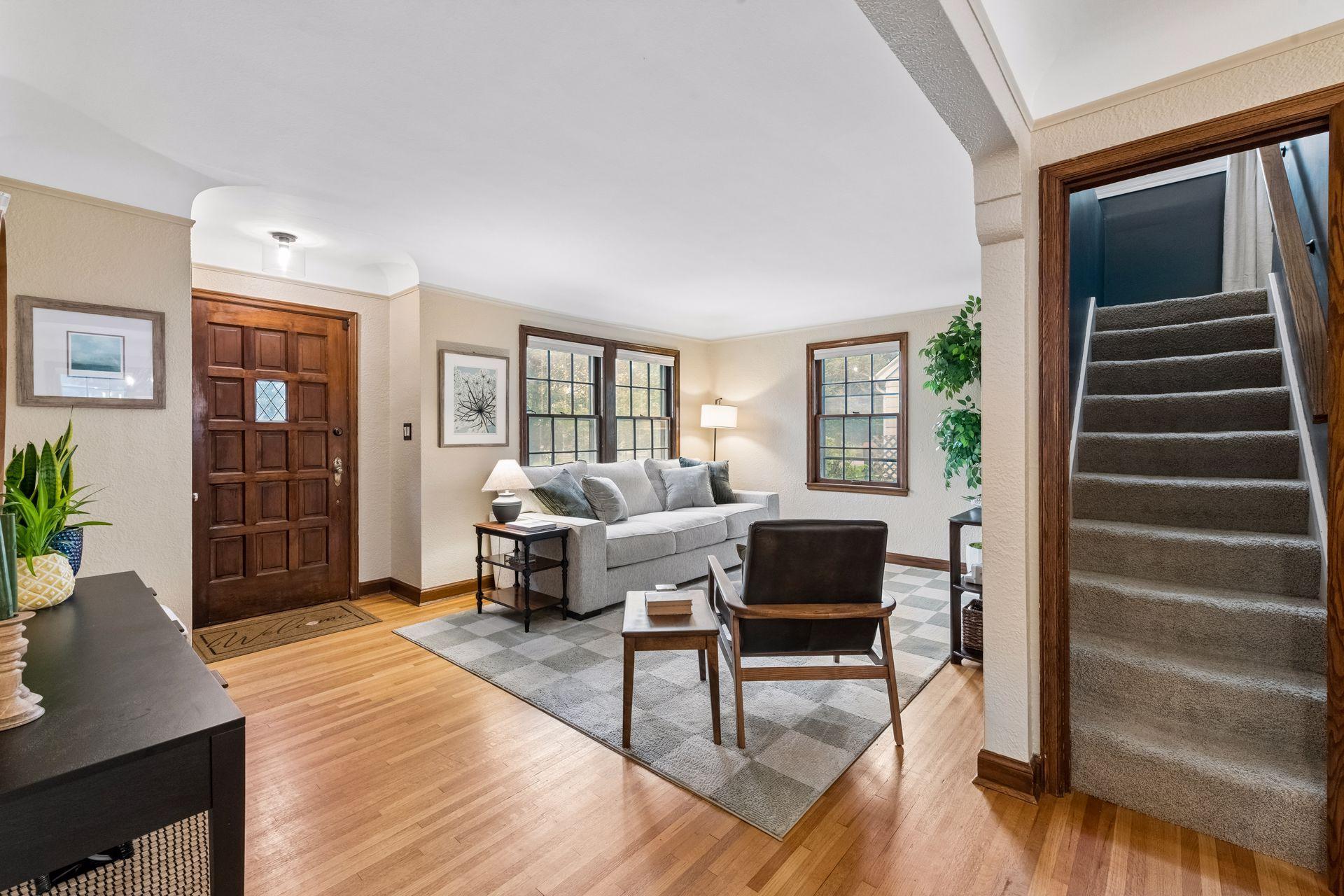 Step inside to an inviting living room featuring a coved ceiling and large windows that fill the space with natural light. Hardwood floors flow into the dining room, while the enameled kitchen overlooks a beadboard sunroom.