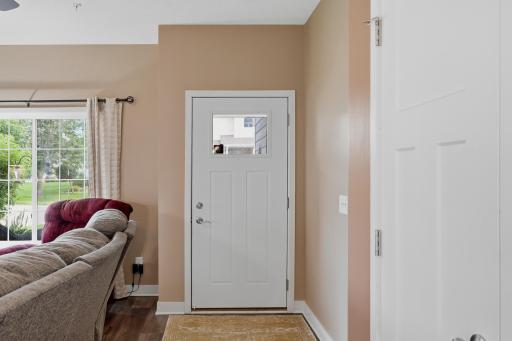 Welcoming Front Entry Features a Storm Door and Nearby Coat Closet, with Easy Access to the Open Main-Level Living Area