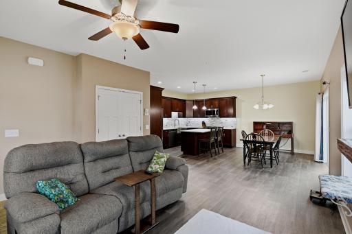 Spacious Open-Concept Main Level Featuring Warm-Toned Finishes that Create an Inviting Flow Between the Living Room, Dining Area and Kitchen.