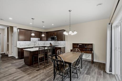 Open Dining and Kitchen Area Offers Excellent Lighting with Ceiling and Pendant lights, Creating a Bright and Welcoming Space for Everyday Living and Entertaining