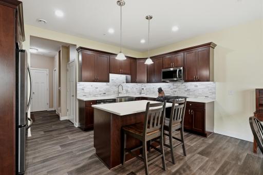 Spacious Kitchen Features a Beautiful Tile Backsplash, Under-Cabinet Lighting and an Abundance of Cabinet Storage