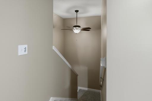Stairway Leading to the Upper Level Features a Ceiling Fan for Added Air Circulation Between Floors. New Upper-Level Carpeting (2023)