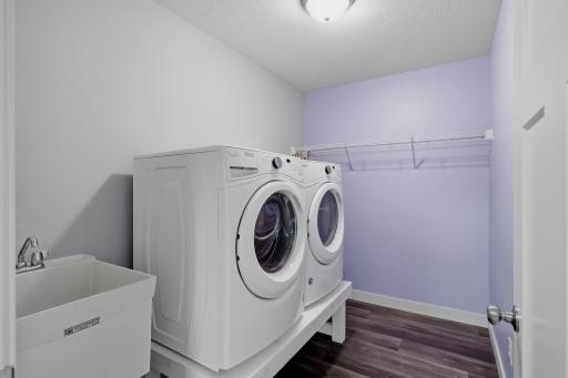 Upper -Level Laundry Room Features a Washer and Gas Dryer on a Raised Pedestal, Utility Sink Additional Shelving for Storage