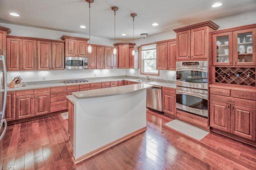Gourmet kitchen features double wall ovens, plentiful cherry cabinetry, butler pantry, and center island prep area