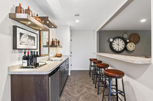 This is where fall entertaining happens with a fantastic wet bar with fridge, sink, and corner pantry overlooking the living room and flat screen TV, making this the ultimate spot for watching the big game with family and friends.