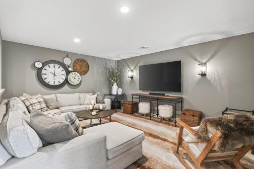 This lower level family room is one of a kind with custom antelope-designed carpet and wall sconces; perfect space to watch a game!