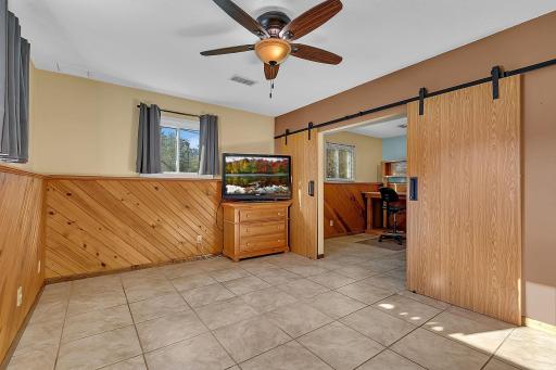 The lower level offers a unique and flexible layout with an additional living area that can be separated into two spaces or transformed into a spacious primary bedroom, providing the potential for a fifth bedroom.