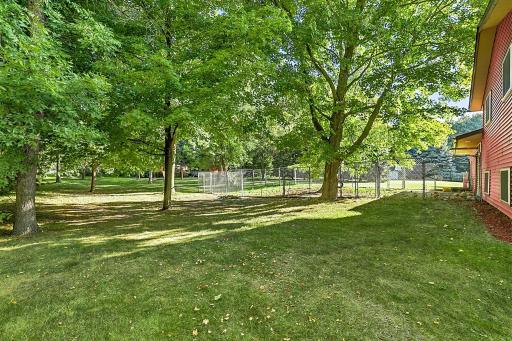 Another view of the large backyard, featuring beautiful mature trees and a convenient fenced-in dog run.