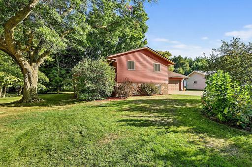 A beautiful view of the home surrounded by an abundance of mature trees and thoughtfully maintained landscaping.