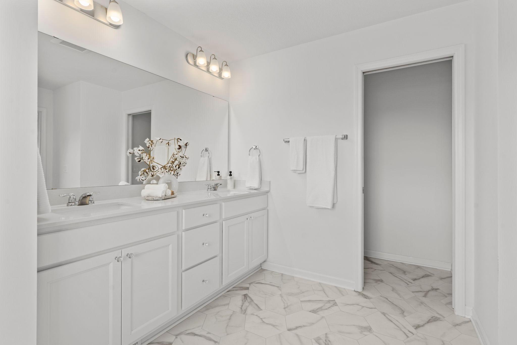 Dual sink in master bath with shower and lots of natural light