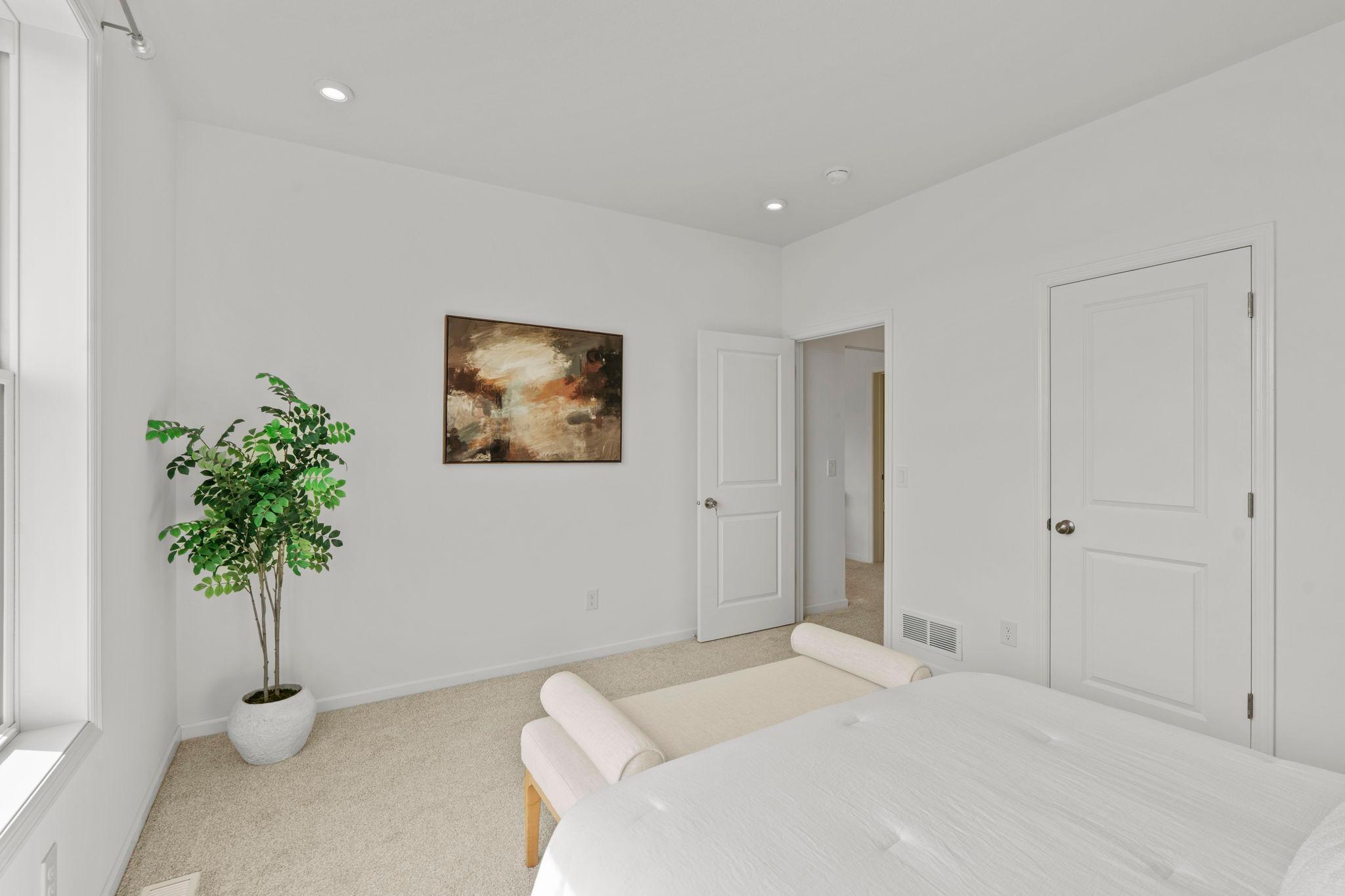 Beautiful main-level bedroom featuring bright natural light, fresh finishes, and convenient accessibility for comfortable everyday living.