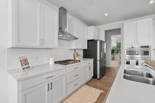 Stainless-steel appliances paired with a sleek modern chimney create a polished, upscale kitchen aesthetic.