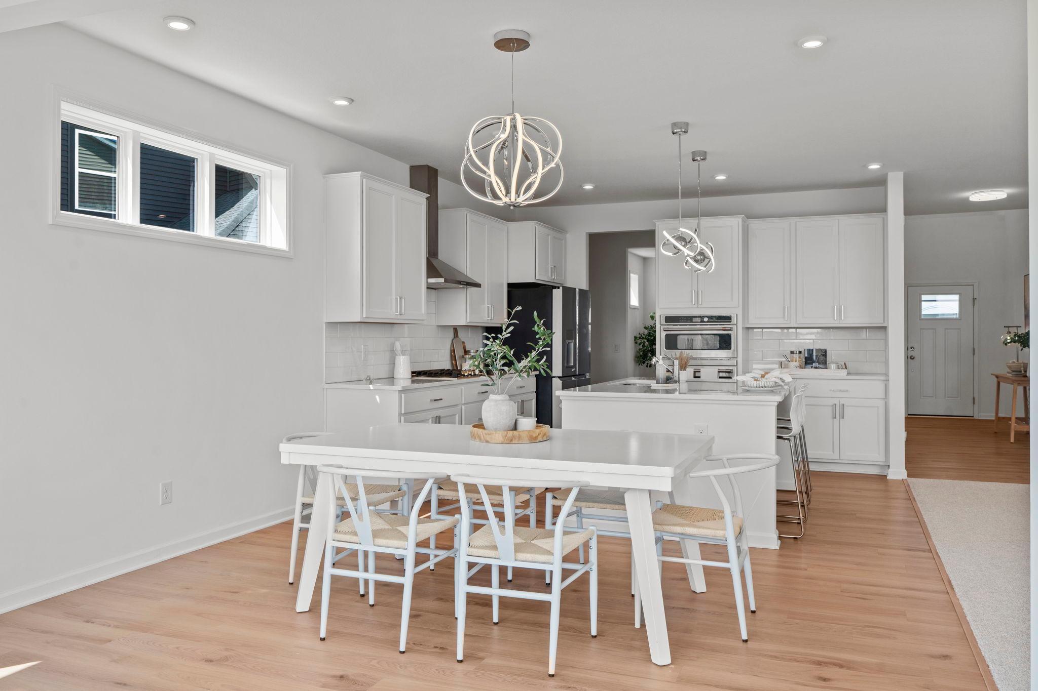 Bright informal dining area adjoining a modern kitchen with a spacious counter and stylish bar stools—perfect for casual meals and easy everyday living.