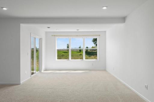 Bright lower-level sunroom wrapped in windows, offering a warm, inviting space with beautiful natural light and seamless connection to the outdoors.