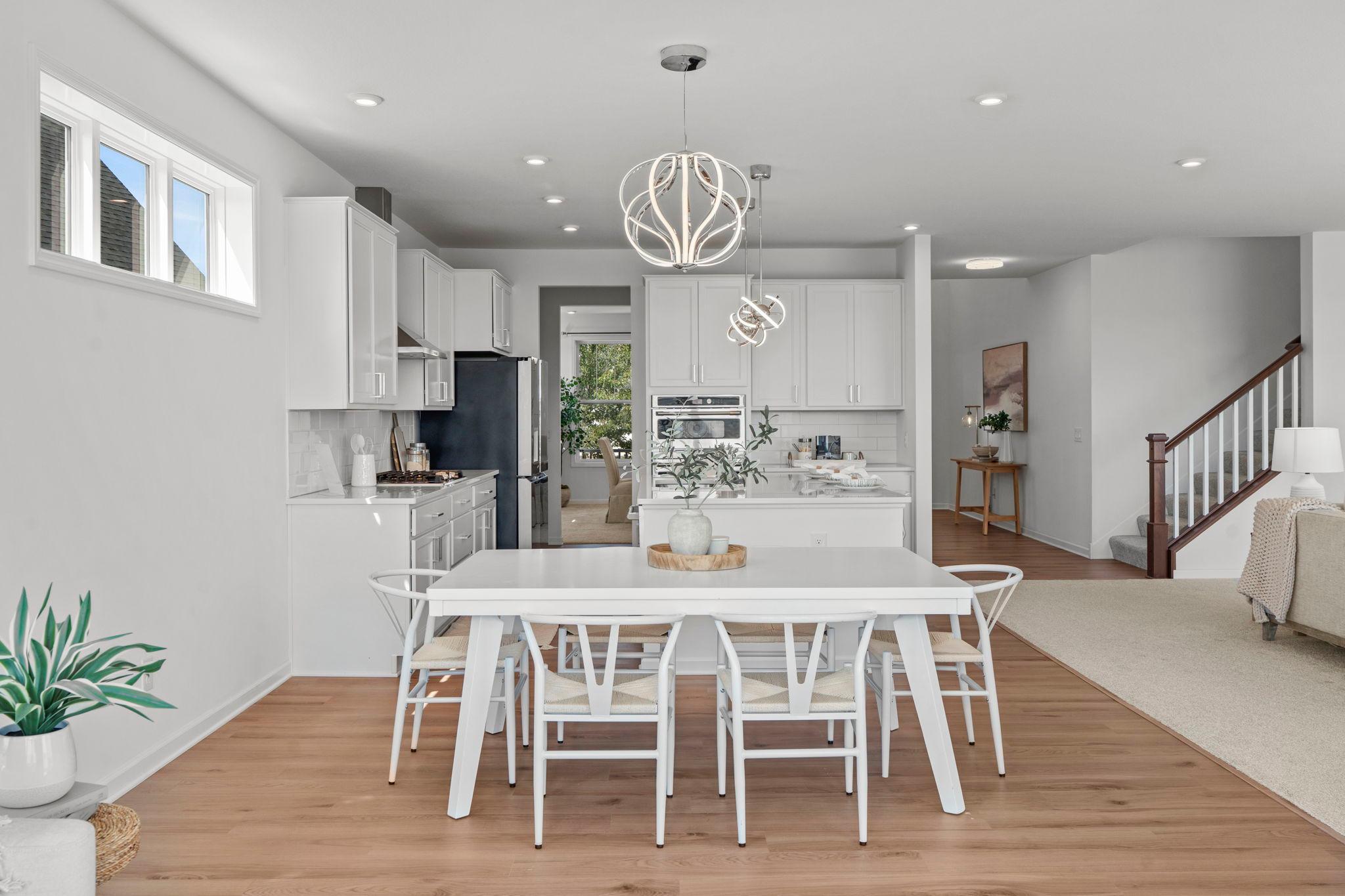 Clean and classy informal dining area adjoining a modern kitchen with a sleek counter and bar-stool seating for effortless everyday living.