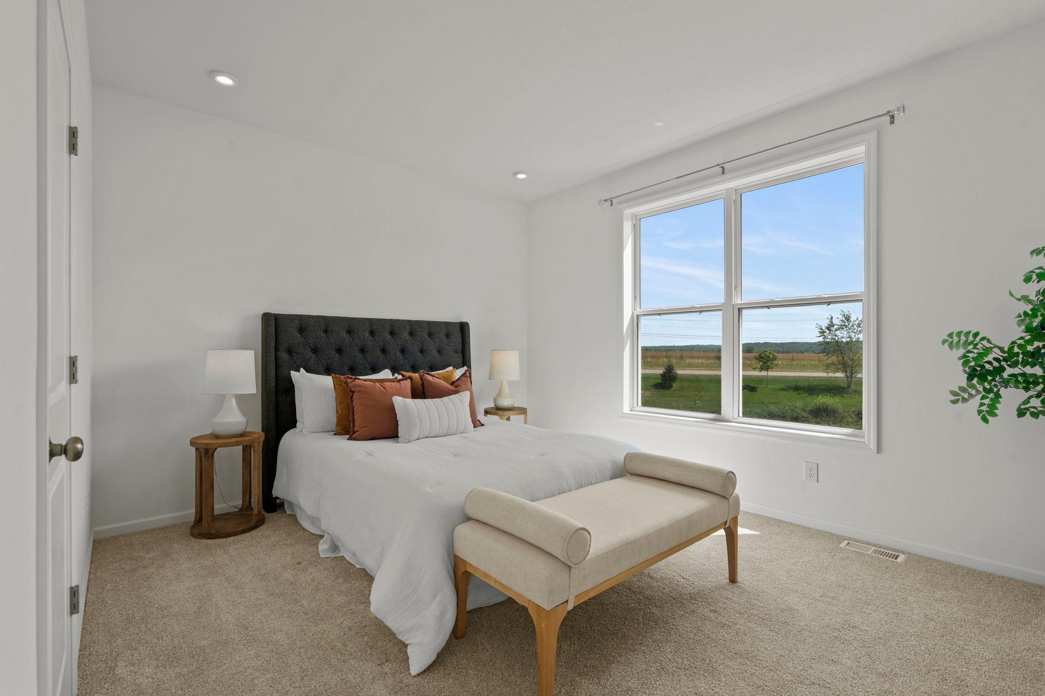 Beautiful main-level bedroom featuring bright natural light, fresh finishes, and convenient accessibility for comfortable everyday living.