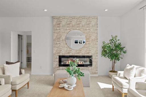 Spacious living room featuring a beautiful gas fireplace and a stunning oversized window that fills the space with natural light.