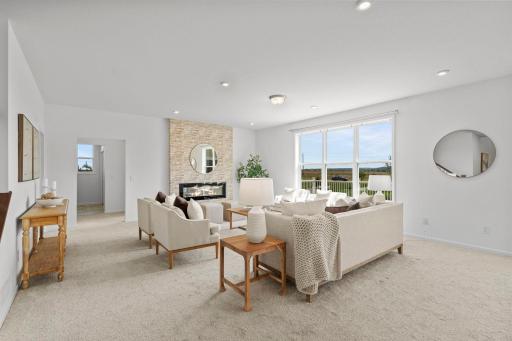 Elegant living room centered around a beautiful gas fireplace, complemented by a dramatic oversized window that floods the space with natural light and highlights the roomâs warm, inviting atmosphere.