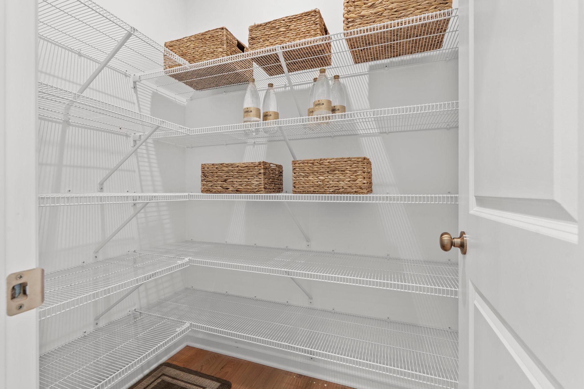 Expansive walk-in pantry offering exceptional storage and a beautifully organized space for all your kitchen essentials.