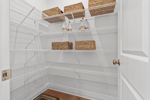 Expansive walk-in pantry offering exceptional storage and a beautifully organized space for all your kitchen essentials.