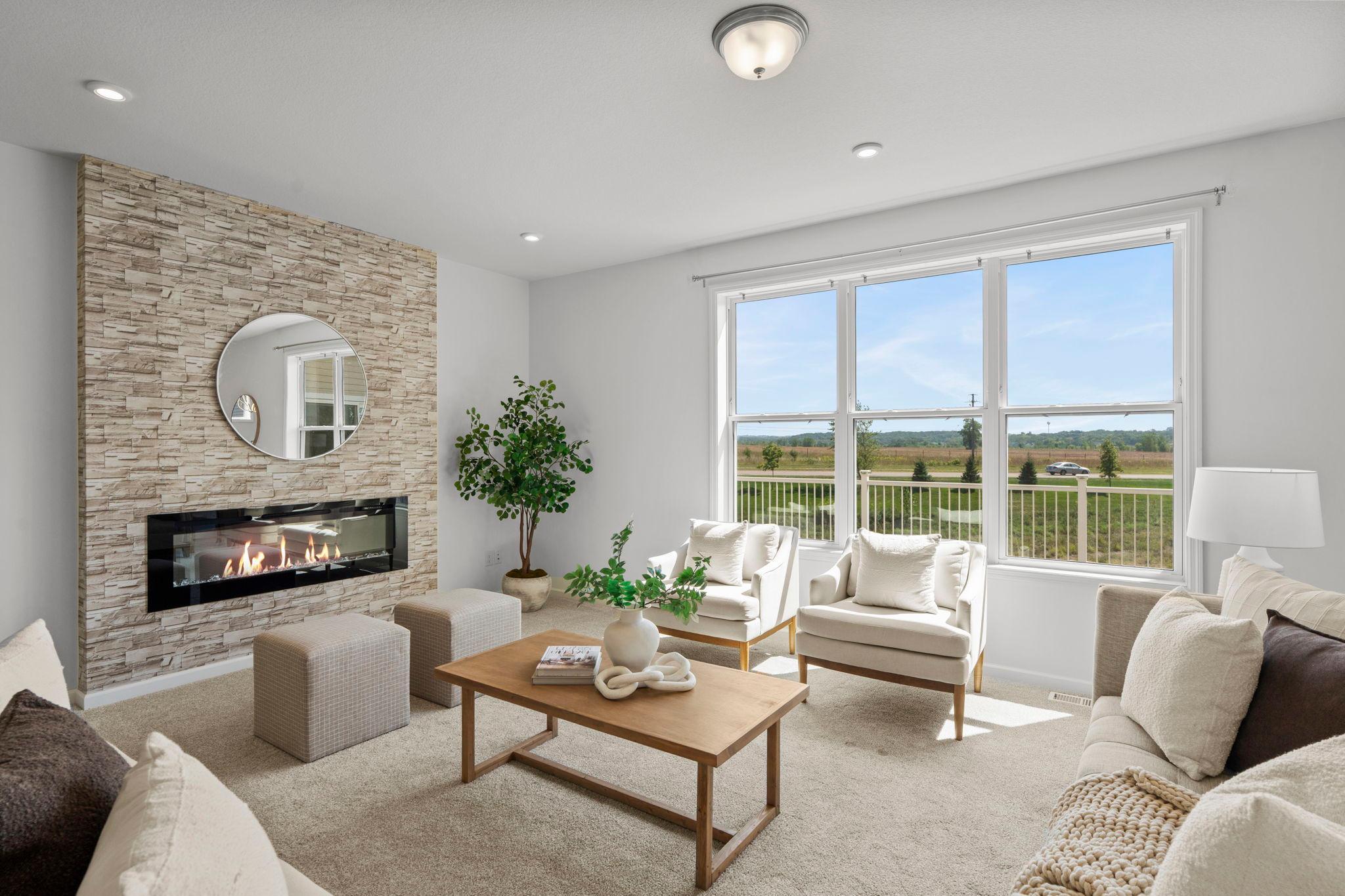 Spacious living room featuring a beautiful gas fireplace and a stunning oversized window that fills the space with natural light.