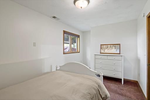 Lower-level bedroom offers a comfortable, private space with closet storage and an egress window for natural light