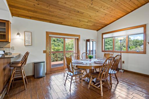 Sunlit dining area seats a crowd with sliding doors opening straight to the deck