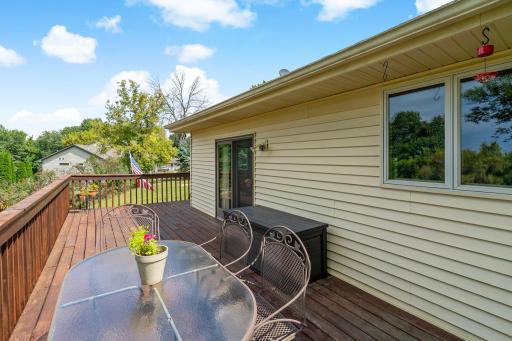 Spacious back deck is ready for morning coffee or evening dinners, with sweeping views of the yard beyond