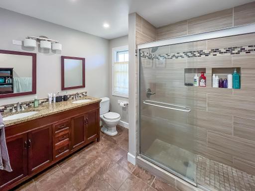 Updated bathroom featuring a spacious vanity, modern finishes and a beautifully tiled shower.